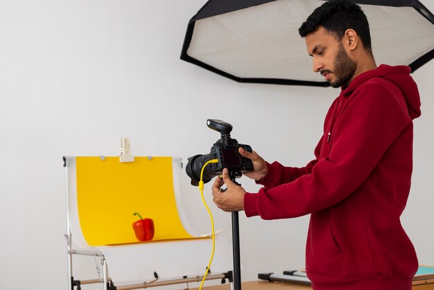 Mittlere Aufnahme spezialisierter Fotograf, der im Studio arbeitet