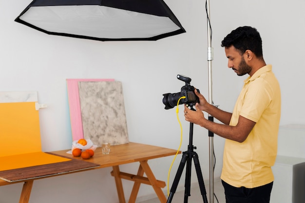 Mittlere Aufnahme spezialisierter Fotograf, der im Studio arbeitet