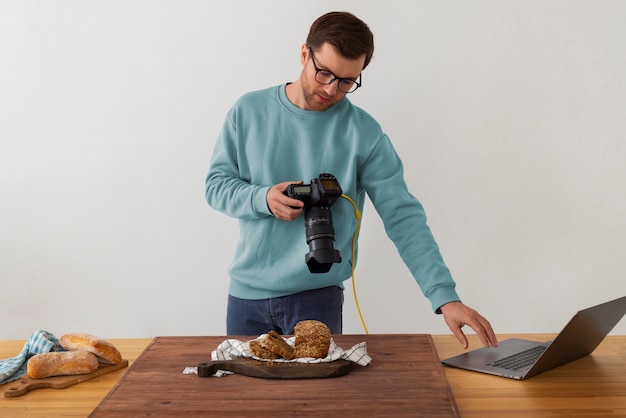 Mittlere Aufnahme spezialisierter Fotograf, der im Studio arbeitet