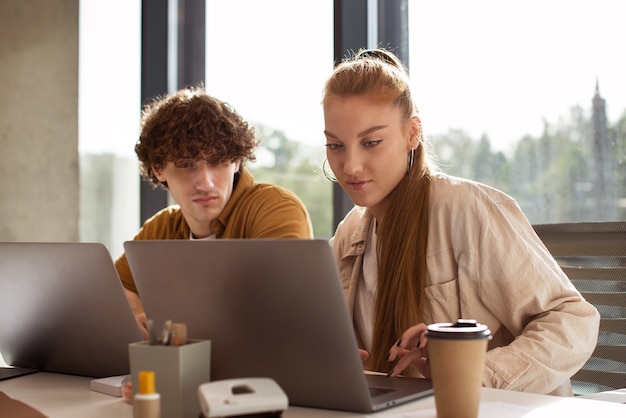 Mittlere Aufnahme von Leuten, die an Laptops arbeiten