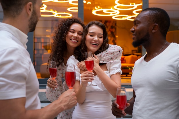 Kostenloses Foto mittlere aufnahme von leuten, die eine dinnerparty genießen