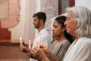 Kostenloses Foto mittlere aufnahme von menschen, die zusammen beten