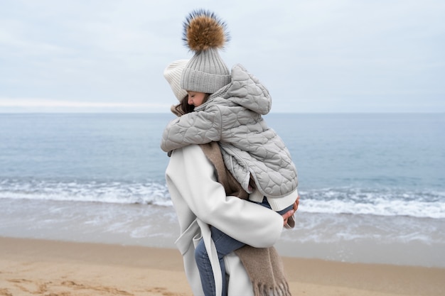 Kostenloses Foto mittlere aufnahme von mutter und kind am strand