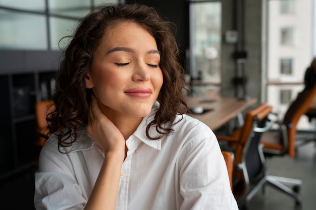 Kostenloses Foto mittlere einstellung einer frau, die sich bei der arbeit dehnt