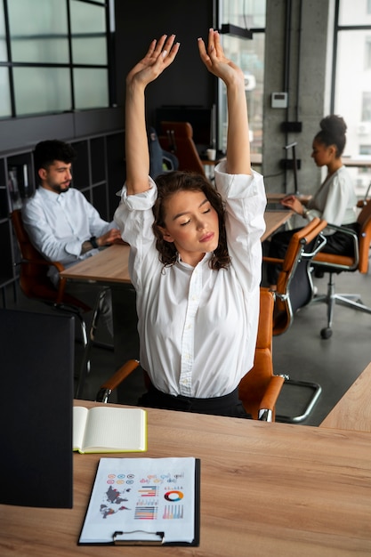 Mittlere Einstellung einer Frau, die sich bei der Arbeit dehnt