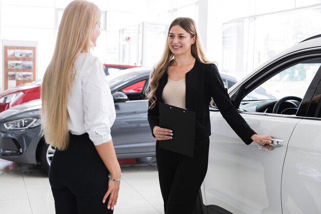 Mittlere Einstellung von Frauen im Autohaus