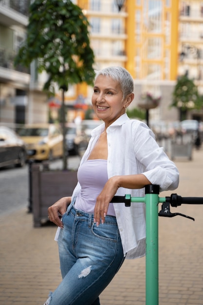 Mittlere geschossene ältere Frau mit Roller