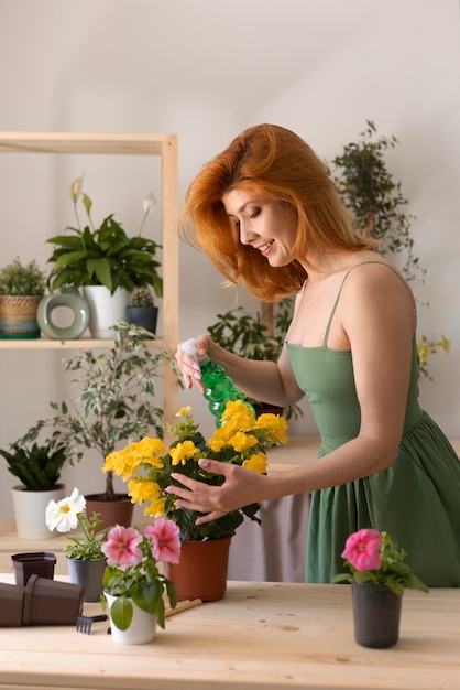 Mittlere geschossene Frau gießt Blume