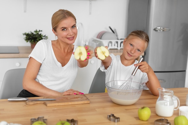 Mittlere geschossene Frau und Mädchen mit Äpfeln