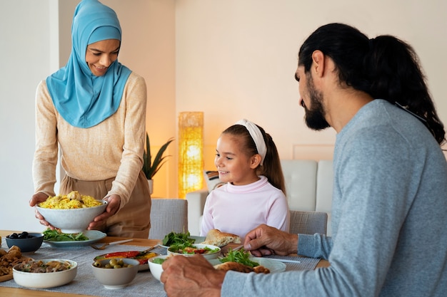 Kostenloses Foto mittlere islamische familie mit leckerem essen