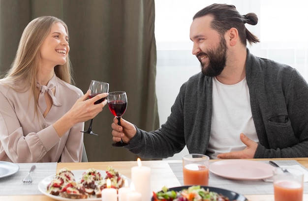 Mittlere Schuss Frau und Mann klirren Gläser