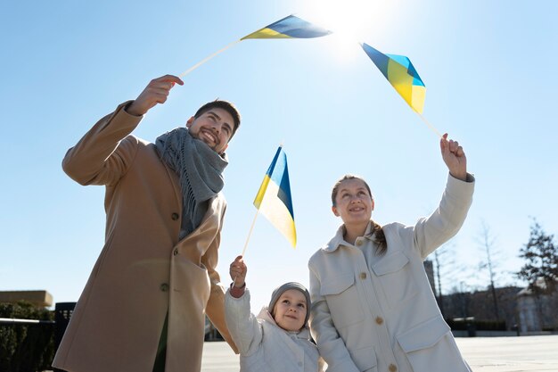 Mittlere schuss glückliche familie mit ukrainischen flaggen