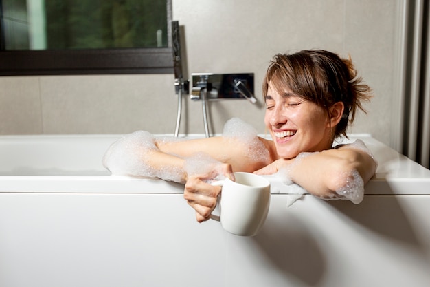 Mittlere Schuss glückliche Frau in der Badewanne