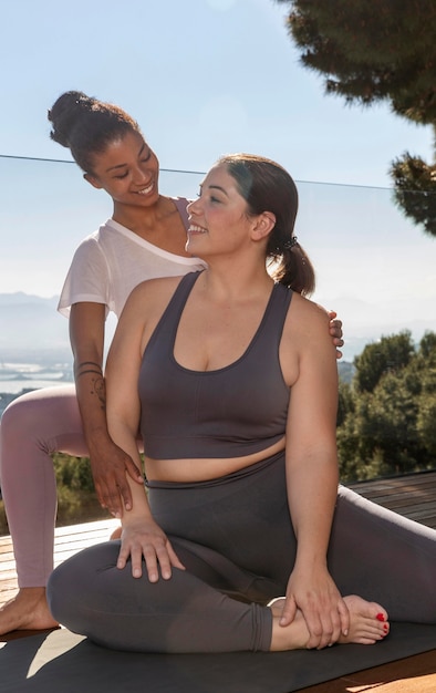 Mittlere Schuss glückliche Frauen, die Yoga machen