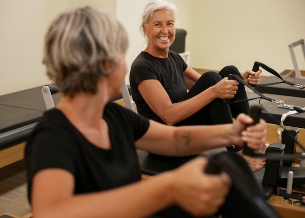 Mittlere Schuss Senioren Frauen in Pilates Reformer Klasse