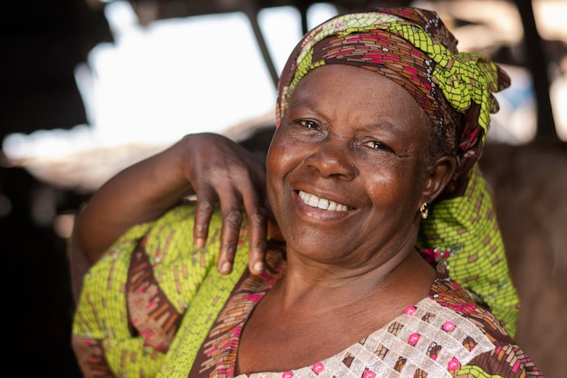 Kostenloses Foto mittlere schuss-smiley-afrikanische frau draußen