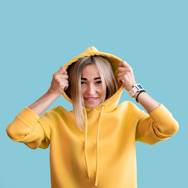 Mittlere Schuss smiley asiatische Frau, die einen gelben Kapuzenpulli trägt
