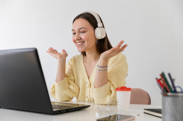 Mittlere Schuss-Smiley-Frau am Schreibtisch