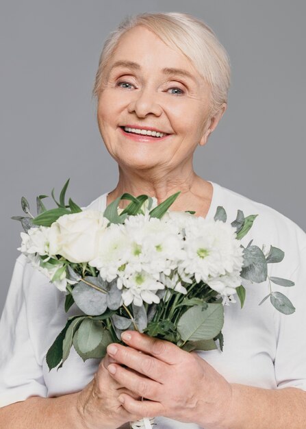 Mittlere Schuss-Smiley-Frau, die Blumen hält