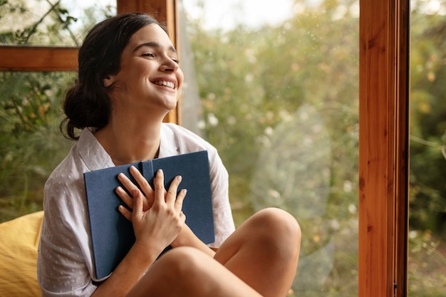 Kostenloses Foto mittlere schuss-smiley-frau, die buch hält