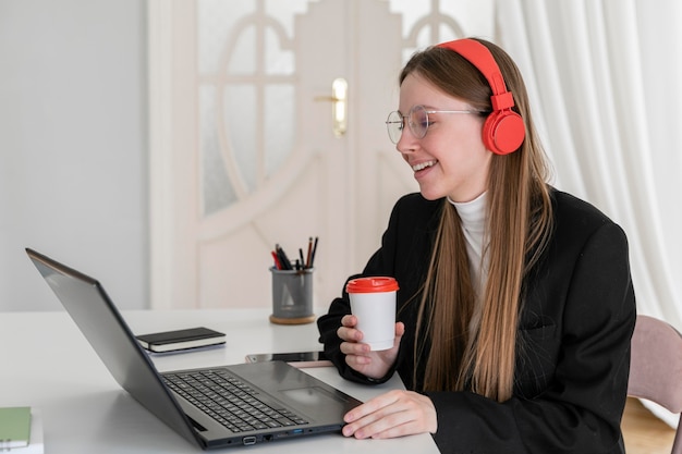 Mittlere Schuss-Smiley-Frau, die Kaffeetasse hält