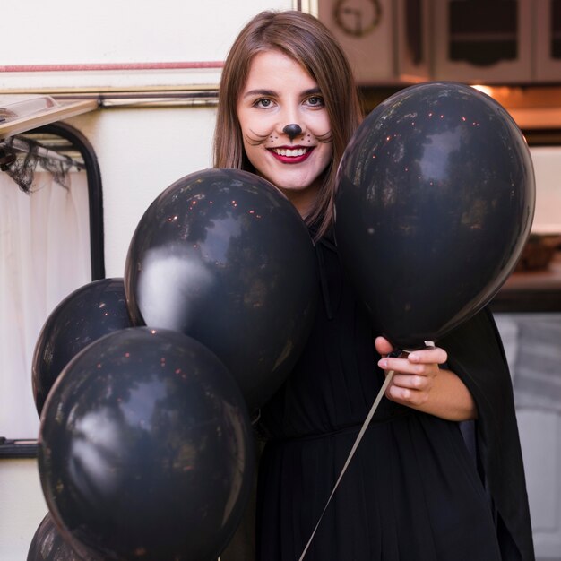 Mittlere Schuss-Smiley-Frau, die Luftballons hält