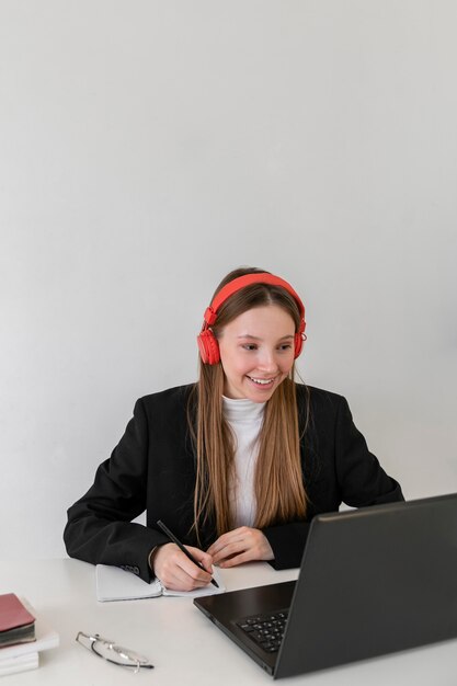 Mittlere Schuss-Smiley-Frau, die mit Laptop arbeitet