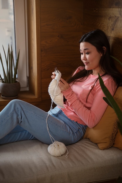 Kostenloses Foto mittlere schuss-smiley-frau, die strickt