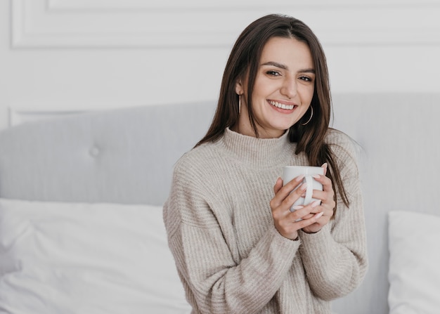 Mittlere Schuss-Smiley-Frau, die Tasse hält