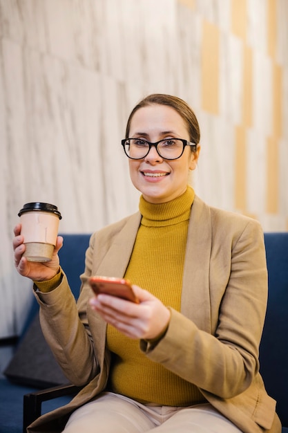 Mittlere Schuss-Smiley-Frau, die Tasse hält