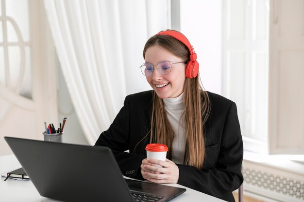 Mittlere Schuss-Smiley-Frau, die Tasse hält