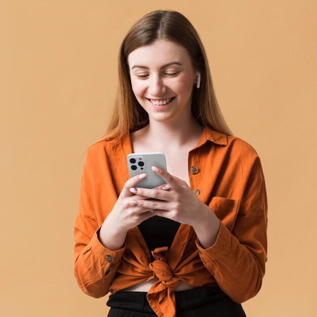 Mittlere Schuss-Smiley-Frau, die Telefon hält