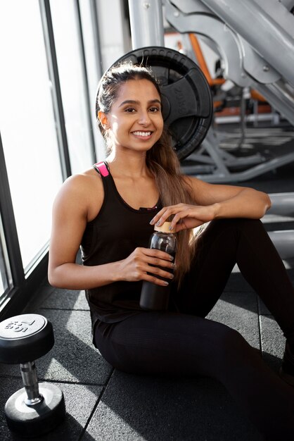 Mittlere schuss-smiley-frau im fitnessstudio