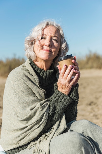 Mittlere Schuss-Smiley-Frau mit Kaffeetasse