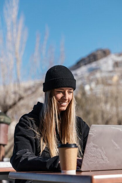 Mittlere Schuss-Smiley-Frau mit Laptop