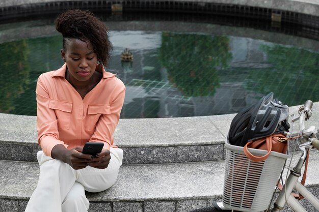 Mittlere Schuss-Smiley-Frau mit Smartphone