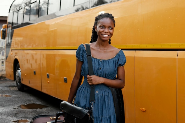 Kostenloses Foto mittlere schuss-smiley-frau nahe bus