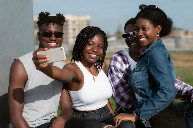 Kostenloses Foto mittlere schuss-smiley-freunde, die selfie nehmen