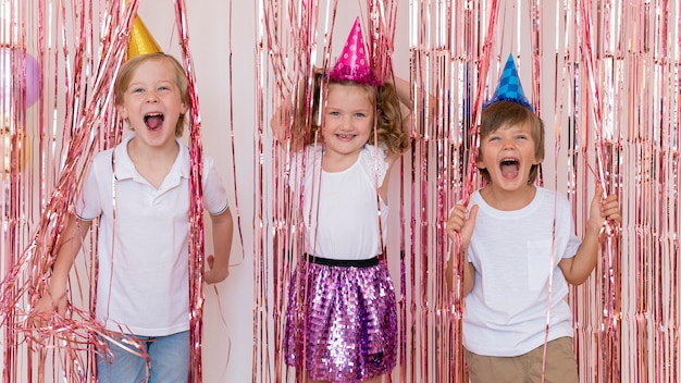 Mittlere schuss-smiley-kinder, die partyhüte tragen