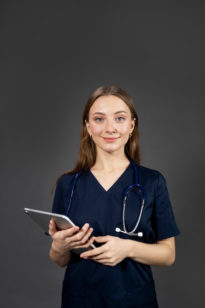 Mittlere Schuss-Smiley-Krankenschwester, die Tablette hält