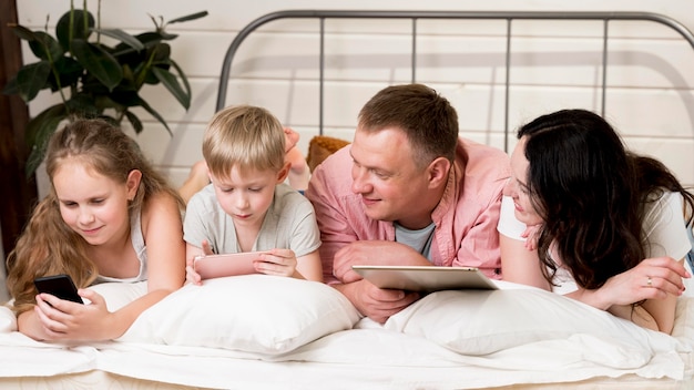 Kostenloses Foto mittlere schussfamilie, die auf kissen legt