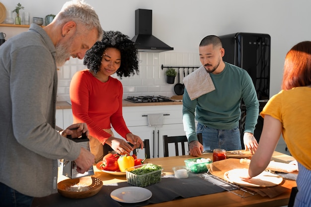 Mittlere Schussfamilie, die köstliche Pizza kocht