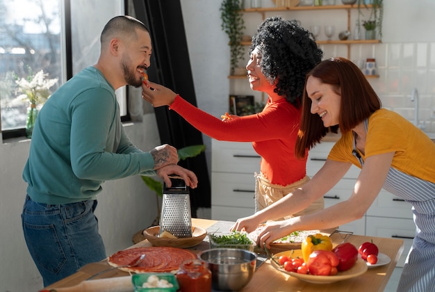 Mittlere Schussfamilie, die köstliche Pizza kocht