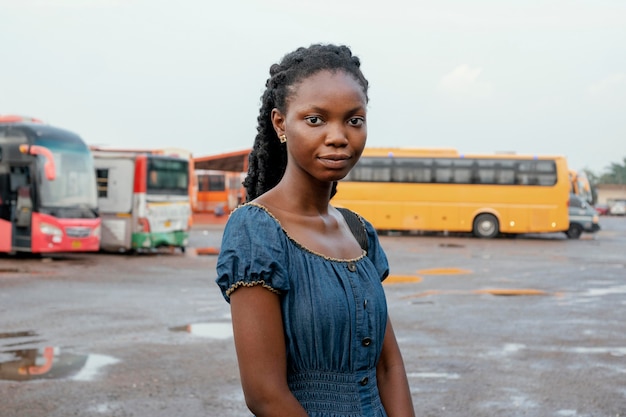 Kostenloses Foto mittlere schussfrau am busbahnhof