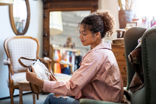 Kostenloses Foto mittlere schussfrau am secondhand-laden