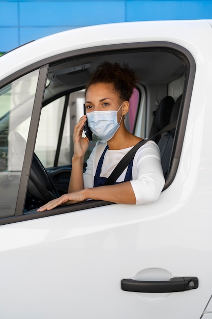 Kostenloses Foto mittlere schussfrau, die als fahrer arbeitet