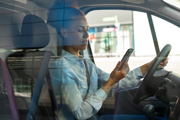 Kostenloses Foto mittlere schussfrau, die als fahrer arbeitet