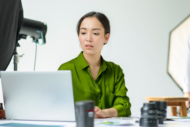 Mittlere Schussfrau, die am Laptop arbeitet