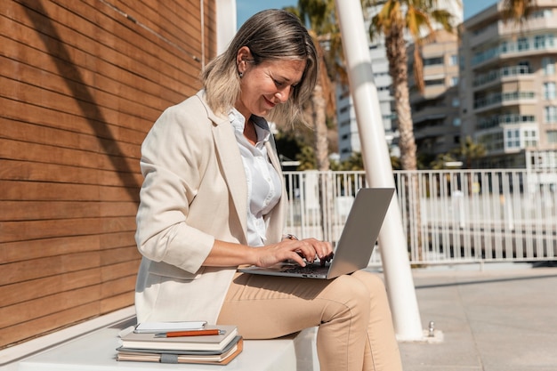 Mittlere Schussfrau, die am Laptop arbeitet