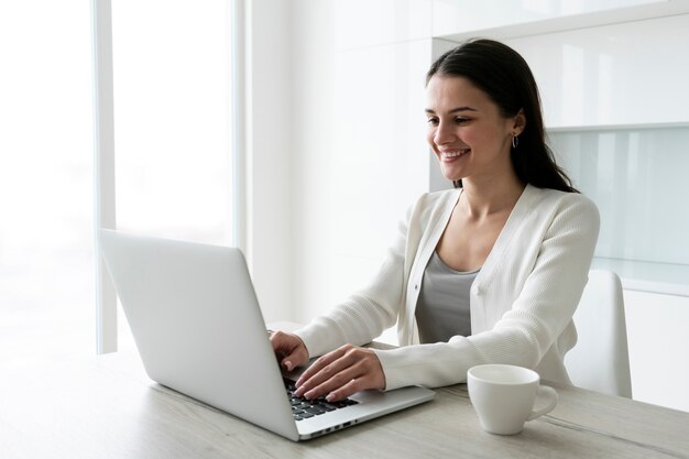 Mittlere Schussfrau, die am Laptop arbeitet